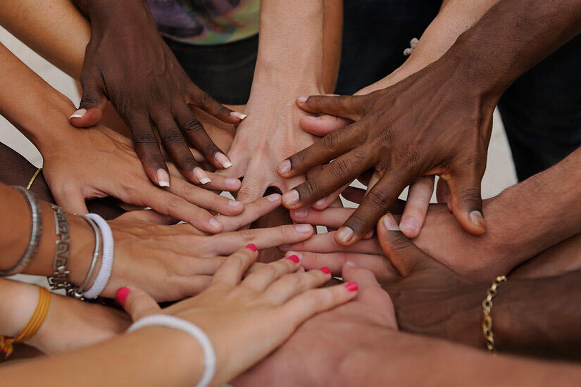 People put their hands in together as if they are "all in." (Many have very pretty fingernails!) 