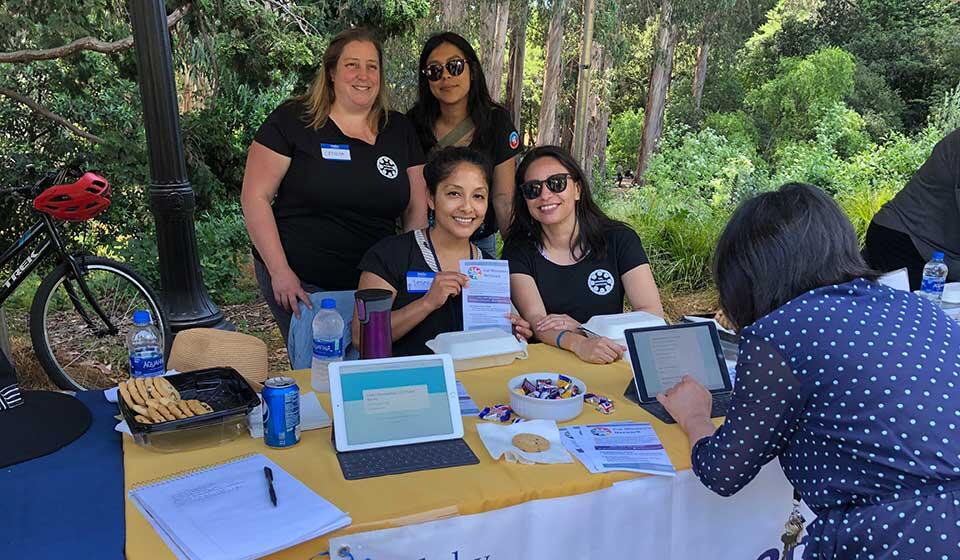 Cal Women's Network smile while tabling at an outreach event